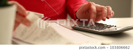 Hands of a female accountant with help of calculator considers expenses on checks 103806662