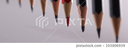 Red pencil stands out from crowd of many identical black pencils Red pencil stands out from crowd of many identical black pencils 103806939