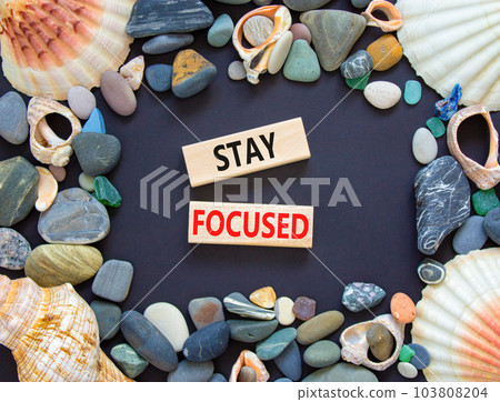 Stay focused symbol. Concept words Stay focused on wooden blocks on a beautiful black table black background. Business, support, motivation, psychological and stay focused concept. Copy space. 103808204