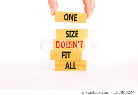 One size does not fit all symbol. Concept words One size does not fit all on wooden blocks. Businessman hand. Beautiful white background. One size does not fit all business concept. Copy space. 103808244