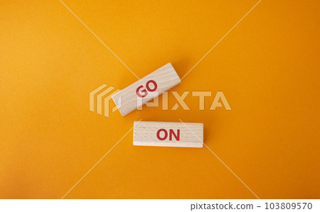 Go on symbol. Wooden blocks with words Go on. Beautiful orange background. Business and Go on concept. Copy space. 103809570