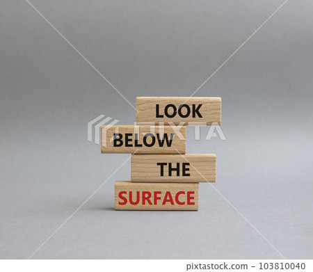 Look below the surface symbol. Concept word Look below the surface on wooden blocks. Beautiful grey background. Business and Look below the surface concept. Copy space 103810040