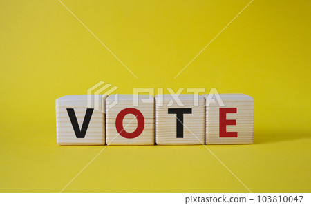 Vote symbol. Concept word Vote on wooden cubes. Beautiful yellow background. Business and Vote concept. Copy space. Vote symbol. Concept word Vote on wooden cubes. Beautiful yellow background. Business and Vote concept. Copy space. 103810047