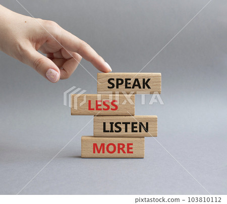 Speak less Listen more symbol. Wooden blocks with words Speak less Listen more. Beautiful grey background. Businessman hand. Business and Speak less Listen more concept. Copy space. 103810112