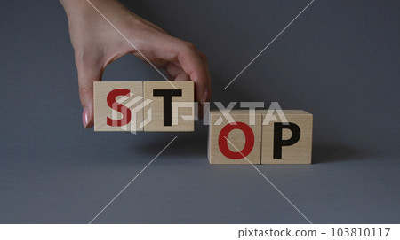 Stop symbol. Concept word Stop on wooden cubes. Businessman hand. Beautiful grey background. Business and Stop concept. Copy space. 103810117