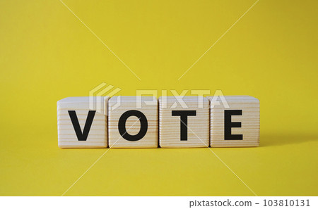 Vote symbol. Concept word Vote on wooden cubes. Beautiful yellow background. Business and Vote concept. Copy space. 103810131