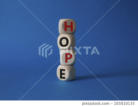 Hope symbol. Concept word Hope on wooden cubes. Beautiful blue background. Business and Hope concept. Copy space. Hope symbol. Concept word Hope on wooden cubes. Beautiful blue background. Business and Hope concept. Copy space. 103810135