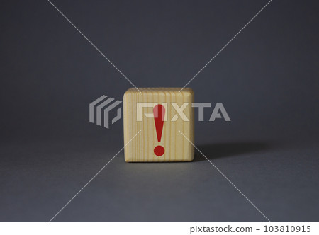 Exclamation mark symbol. Exclamation mark on wooden cubes. Beautiful grey background. Business and Exclamation mark concept. Copy space. Exclamation mark symbol. Exclamation mark on wooden cubes. Beautiful grey background. Business and Exclamation mark concept. Copy space. 103810915