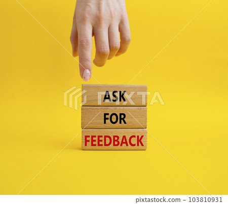 Feedback symbol. Concept word Ask for feedback on wooden blocks. Businessman hand. Beautiful yellow background. Business and Ask for feedback concept. Copy space 103810931