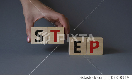 Step symbol. Concept word Step on wooden cubes. Businessman hand. Beautiful grey background. Business and Step concept. Copy space. 103810969