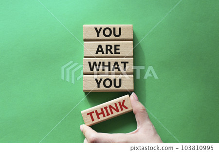 You are what you think symbol. Wooden blocks with words You are what you think. Beautiful green background. Businessman hand. Business and You are what you think concept. Copy space 103810995