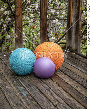 heavy slam balls filled with sand on a backyard deck, exercise and functional fitness concept 103815274