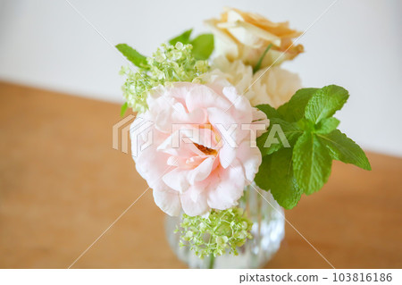 玻璃杯中的粉紅玫瑰和綠色插花 玻璃杯中的粉紅玫瑰和綠色插花 103816186