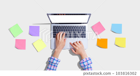 Laptop computer with many sticky notes 103816302