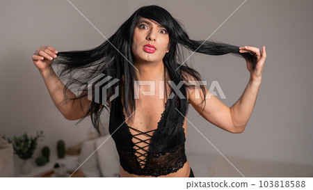 Gay man in wig and black lace lingerie.  103818588