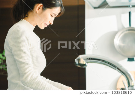 Japanese woman in her 30s cooking in the kitchen Japanese woman in her 30s cooking in the kitchen 103818610