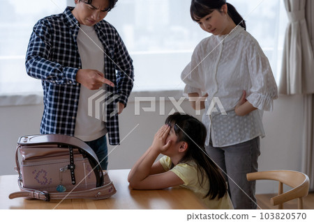 parents scolding their child 103820570