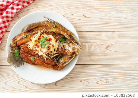 Fried Sea Bass Fish with Fish Sauce and Spicy Salad 103822568