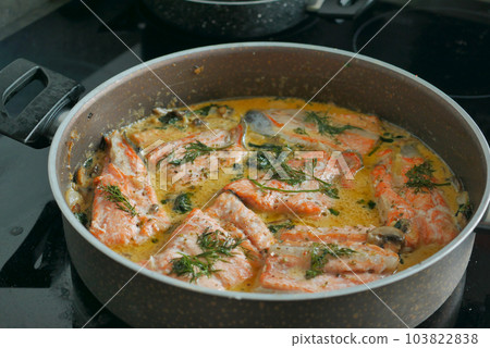 baked salmon fish in a large bowl on stove at kitchen  103822838