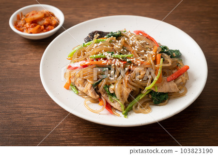japchae or stir-fried Korean vermicelli noodles with vegetables and pork topped with white sesame 103823190