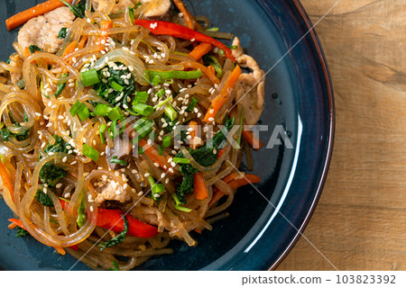 japchae or stir-fried Korean vermicelli noodles with vegetables and pork topped with white sesame 103823392