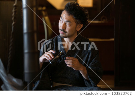 A person who enjoys evening drinks such as sake in an old private house. 103823762