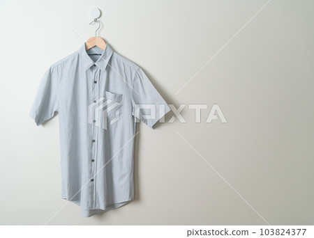 hanging shirt with wood hanger on wall 103824377