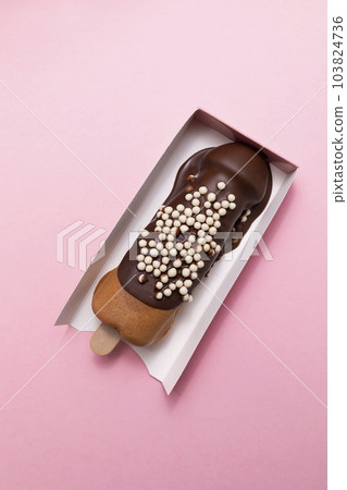 Closeup Penis Shaped Waffle On Wooden Stick With Dark Chocolate, Decorated With White Air Corn Balls In Paper Box On Pink Background. Festival Street Food, Cookie Vertical Plane Closeup Penis Shaped Waffle On Wooden Stick With Dark Chocolate, Decorated With White Air Corn Balls In Paper Box On Pink Background. Festival Street Food, Cookie Vertical Plane 103824736