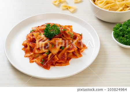 farfalle pasta in tomato sauce with parsley 103824964
