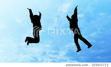 Silhouette of two women jumping _ blue sky background Silhouette of two women jumping _ blue sky background 103825713