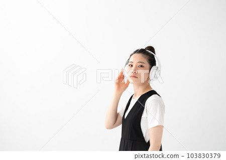 聽到與耳機的音樂的婦女 103830379