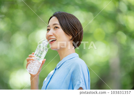 Woman drinking water heat stroke measures fresh green Woman drinking water heat stroke measures fresh green 103831357