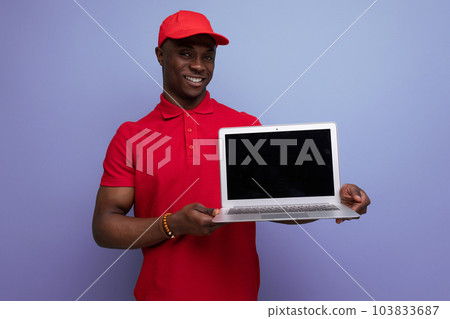 american service employee man in red cap and t-shirt holding laptop with mockup american service employee man in red cap and t-shirt holding laptop with mockup 103833687