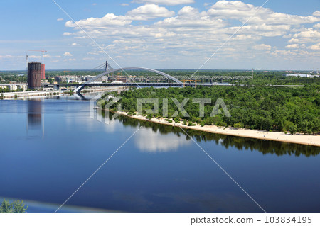 Summer landscape with a view of the Dnipro River, the beach coastline and several bridges over the river. Summer landscape with a view of the Dnipro River, the beach coastline and several bridges over the river. 103834195