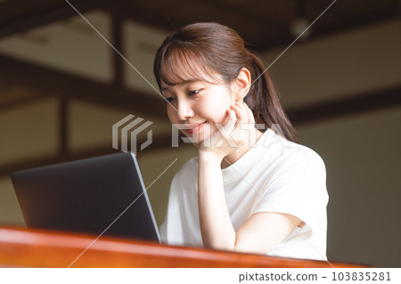 Woman operating a personal computer Woman operating a personal computer 103835281