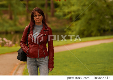 Hipster girl in leather jacket in the park Hipster girl in leather jacket in the park 103835618