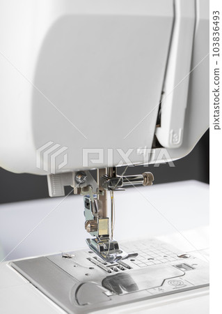 Modern white sewing machine presser foot closeup, macro Modern white sewing machine presser foot closeup, macro 103836493