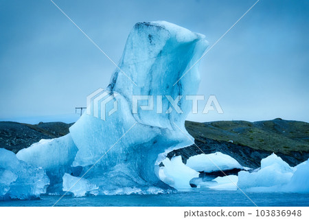 Natural blue iceberg floating and melting in Jokulsarlon glacier lagoon Natural blue iceberg floating and melting in Jokulsarlon glacier lagoon 103836948