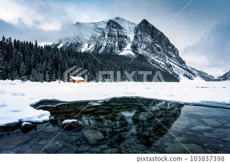 Scenery of Lake Louise with wooden cottage glowing and rocky mountains with snow covered in winter at Banff national park Scenery of Lake Louise with wooden cottage glowing and rocky mountains with snow covered in winter at Banff national park 103837398