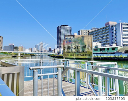A view of the cityscape beyond the signboard of Osaka Dome Chiyozaki Port on the Kizu River, Nishi Ward, Osaka City A view of the cityscape beyond the signboard of Osaka Dome Chiyozaki Port on the Kizu River, Nishi Ward, Osaka City 103837503