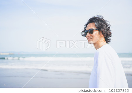 Man wearing sunglasses walking on the beach in summer Man wearing sunglasses walking on the beach in summer 103837833