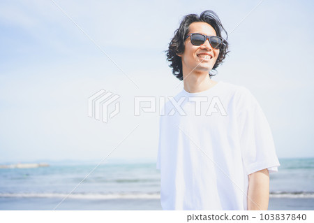 Man wearing sunglasses walking on the beach in summer 103837840