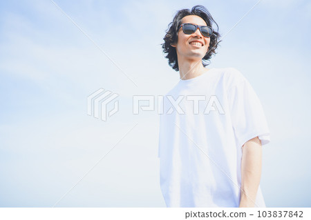 Man wearing sunglasses walking on the beach in summer 103837842