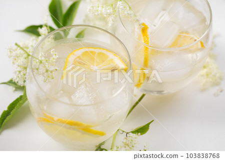 A drink made of elderflowers and lemon with ice on a light background 103838768