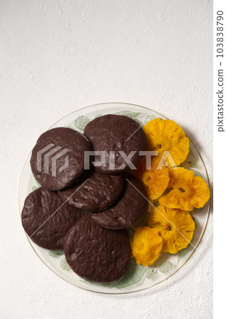 Round cookies in chocolate with cinnamon and candied pineapple, top view 103838790