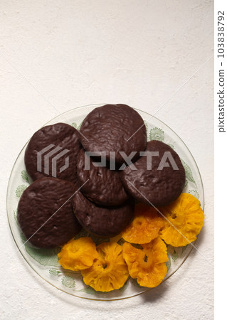 cookies in chocolate with cinnamon and candied pineapple, top view 103838792