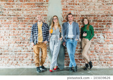 Team of people in startup company standing on brick wall Team of people in startup company standing on brick wall 103839626