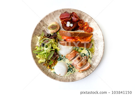 Poached egg with sun-dried tomatoes, bacon roll, prosciutto, and lettuce Poached egg with sun-dried tomatoes, bacon roll, prosciutto, and lettuce 103841150