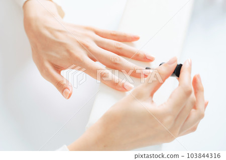Woman doing nail care manicure gel nail 103844316