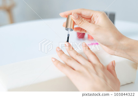 Woman doing nail care manicure gel nail 103844322